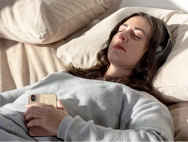 Person relaxing with headphones during a hypnotherapy session